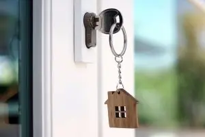 White front door of house with key in lock
