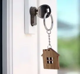 White front door of house with key in lock